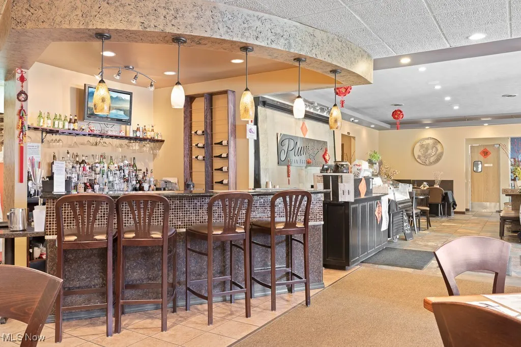 Bar featuring decorative light fixtures and light tile patterned floors