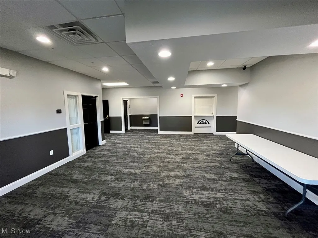 Paneled ceiling and dark colored carpet