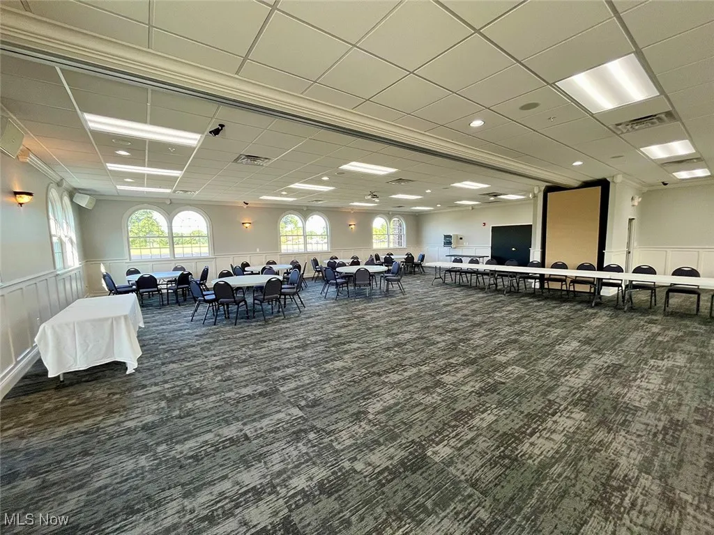Dining area featuring a paneled ceiling and dark colored carpet