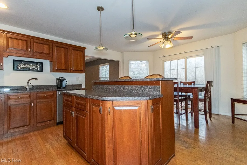 Kitchen featuring light hardwood / wood-style floors, a kitchen island, and sink