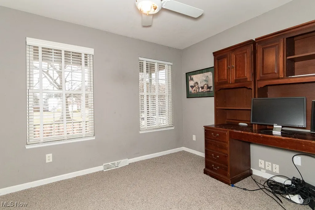 Unfurnished office featuring ceiling fan and light colored carpet