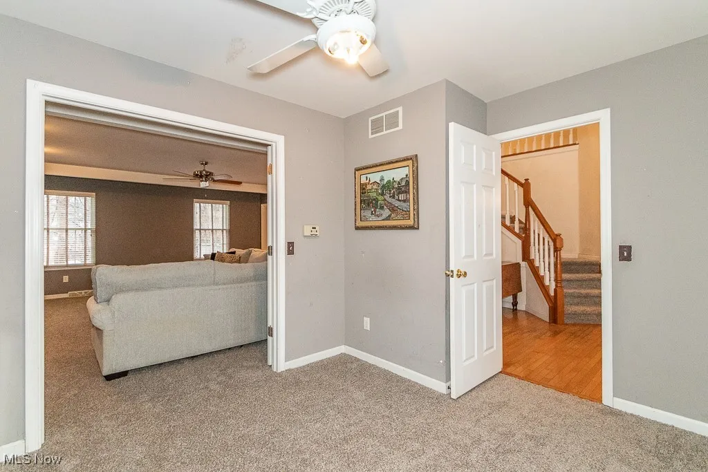Living room featuring ceiling fan and carpet floors