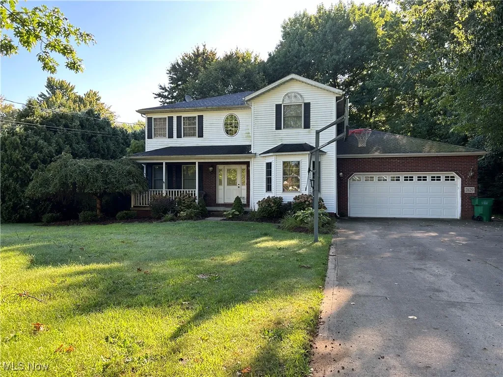 View of front of house with covered porch and a front yard