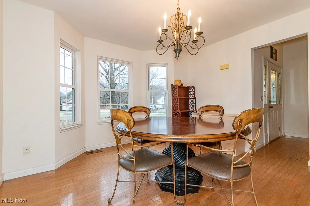 Dining space featuring light wood-type flooring and an inviting chandelier