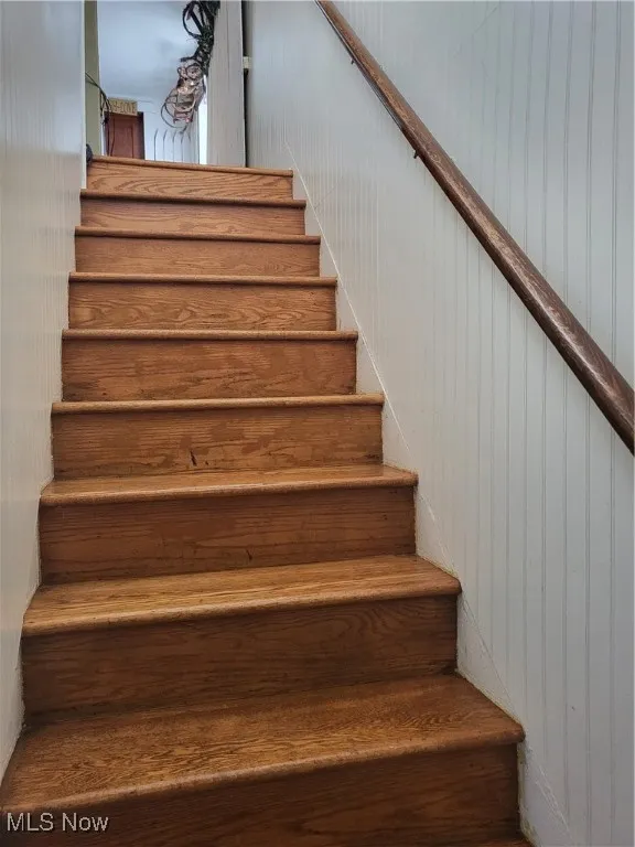 Stairway featuring wood walls