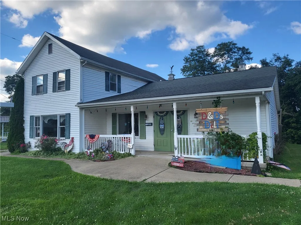 View of front of home with covered porch and a front yard