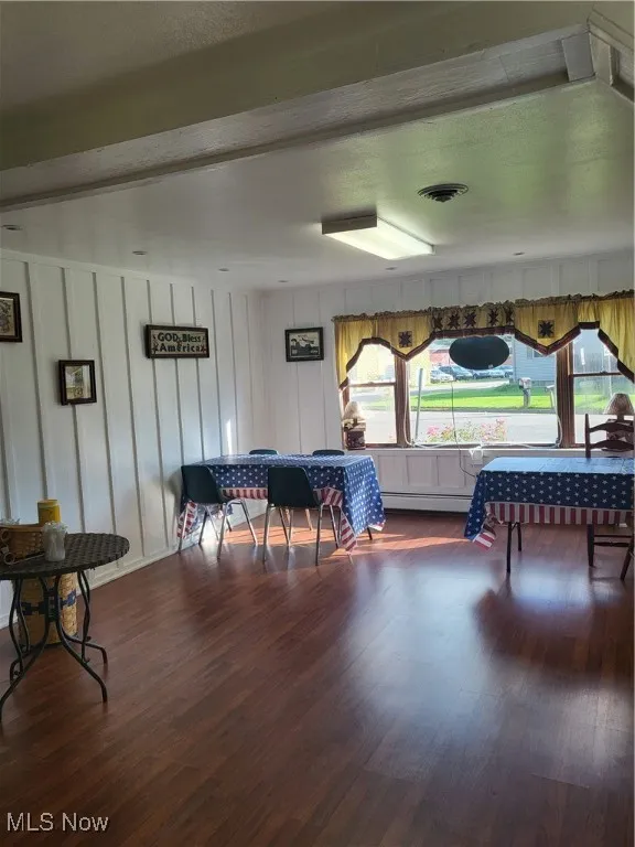Rec room with dark wood-type flooring and beamed ceiling