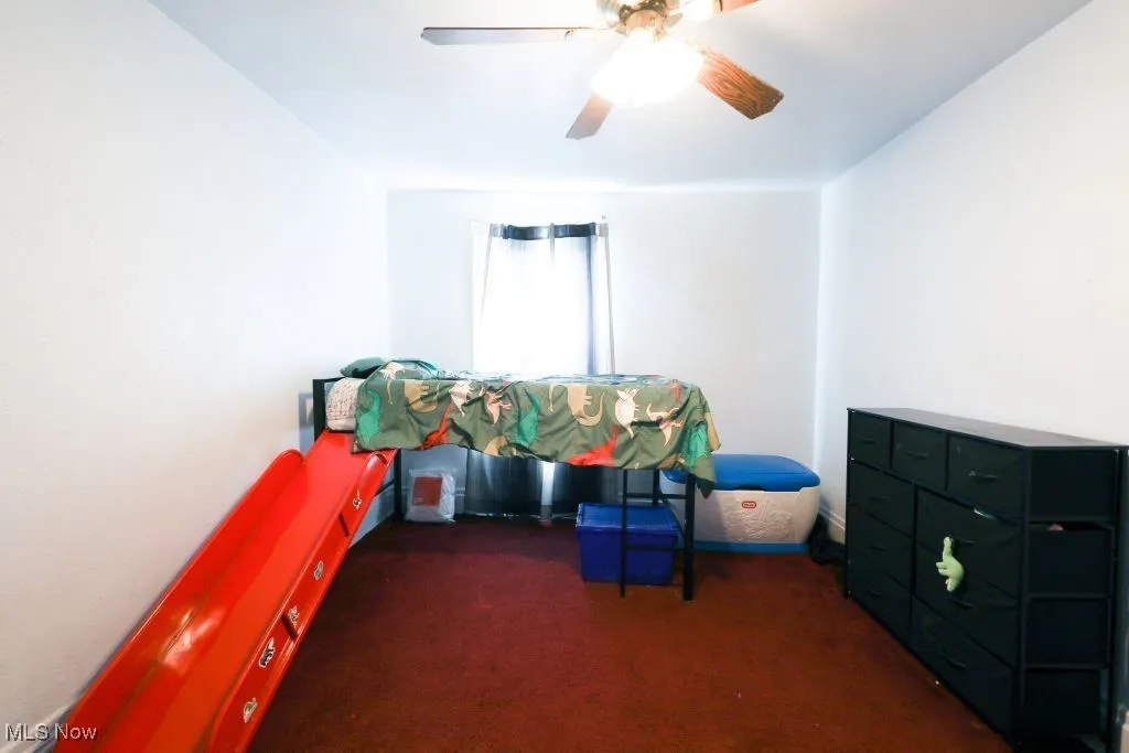 This bedroom measures 13 x 8.  This bedroom features carpet flooring and a ceiling fan.
