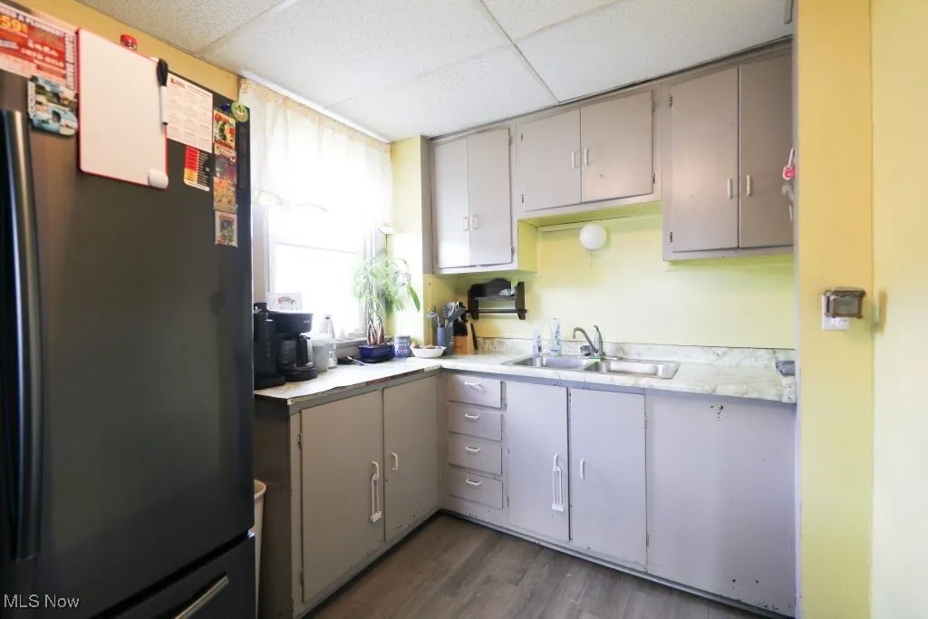 Kitchen features light grey cabinets and Vinyl flooring.  The refrigerator and stove are included with the home.