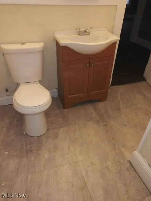 Bathroom featuring vanity, toilet, and wood-type flooring