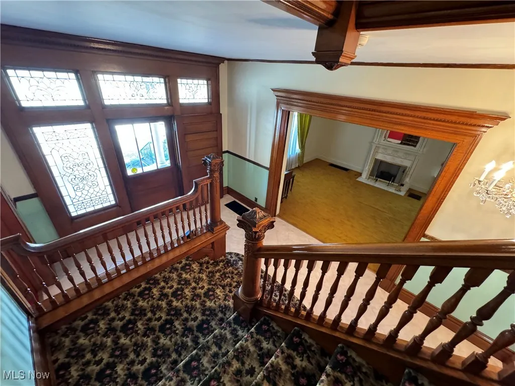 Foyer entrance with a premium fireplace and a notable chandelier