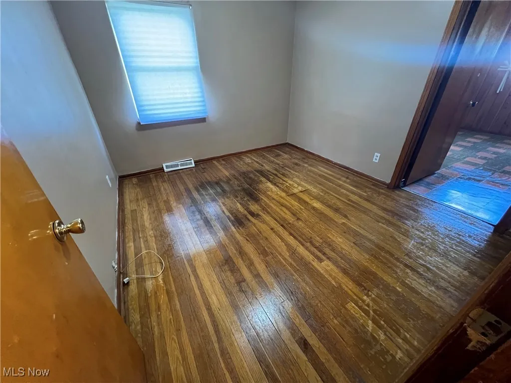 Empty room featuring dark wood-type flooring