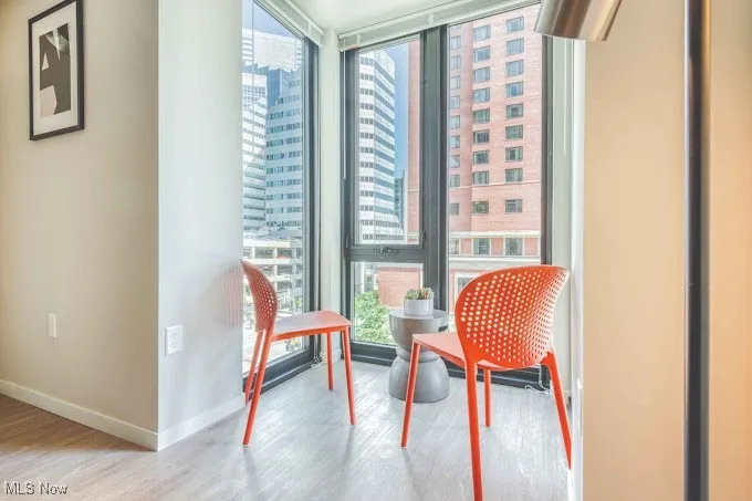 Living area with light hardwood / wood-style flooring and a wall of windows