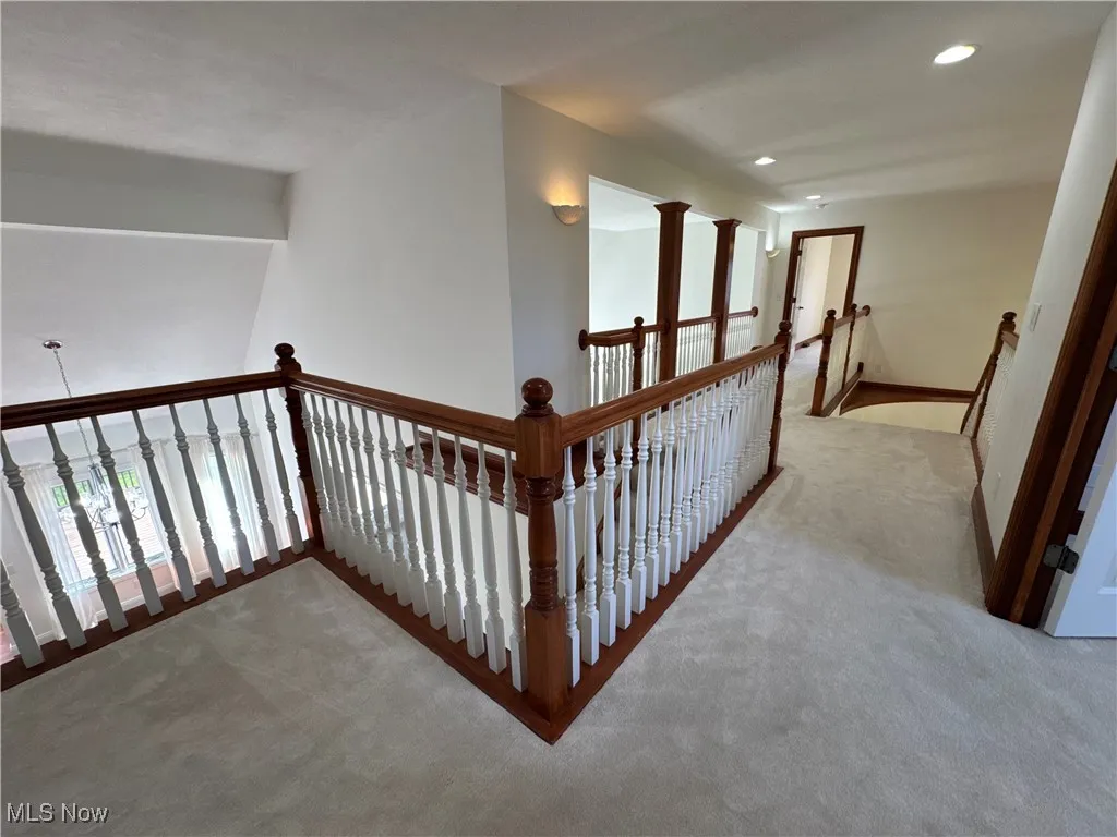 Hall with carpet floors, recessed lighting, baseboards, and an upstairs landing