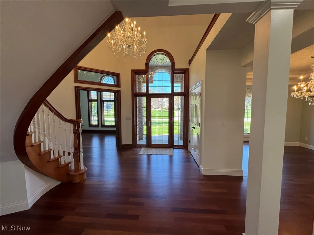 Entrance foyer featuring an inviting chandelier, baseboards, and wood finished floors