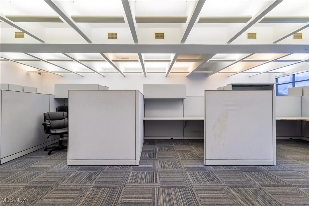 Unfurnished office featuring dark colored carpet