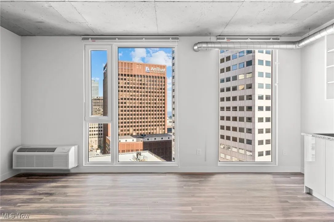 Wine area featuring hardwood / wood-style flooring, a healthy amount of sunlight, and a wall mounted air conditioner