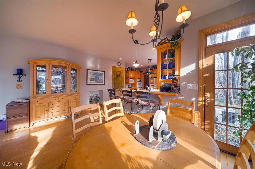 Dining space with an inviting chandelier and light hardwood / wood-style floors