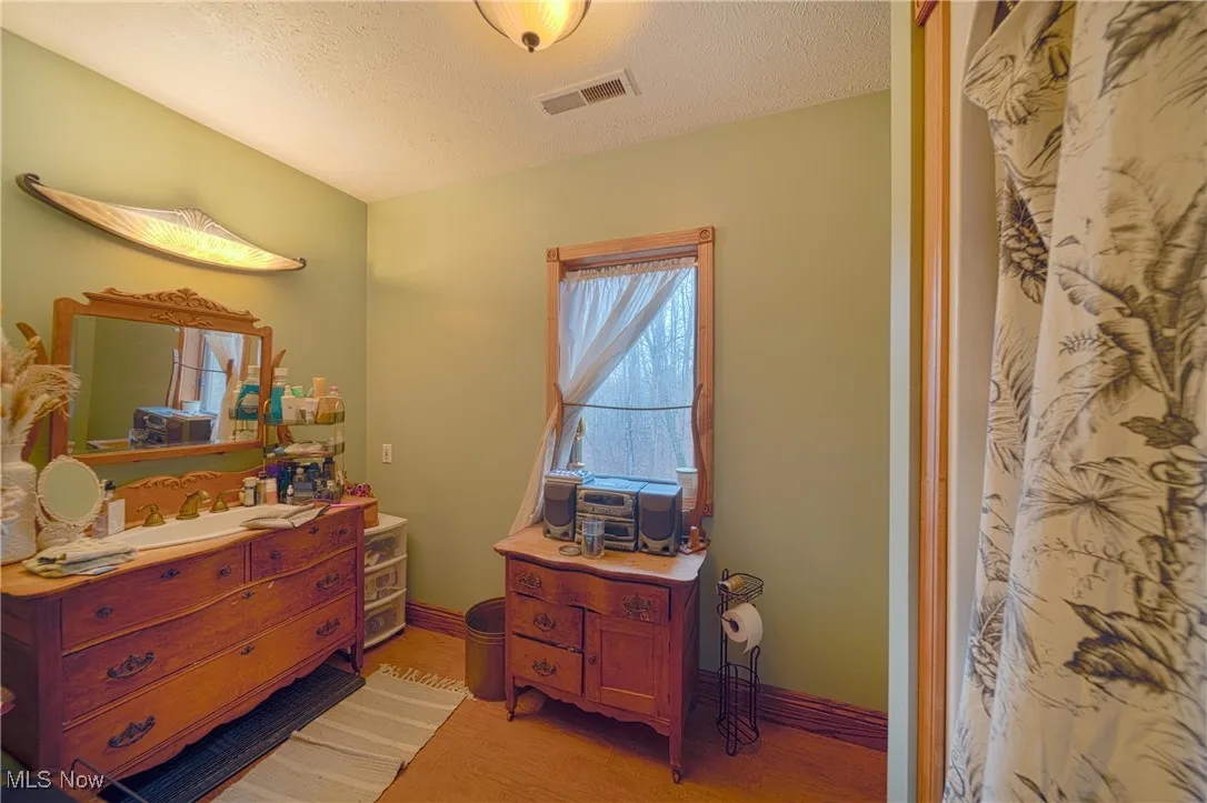 Bedroom featuring hardwood / wood-style flooring and a textured ceiling