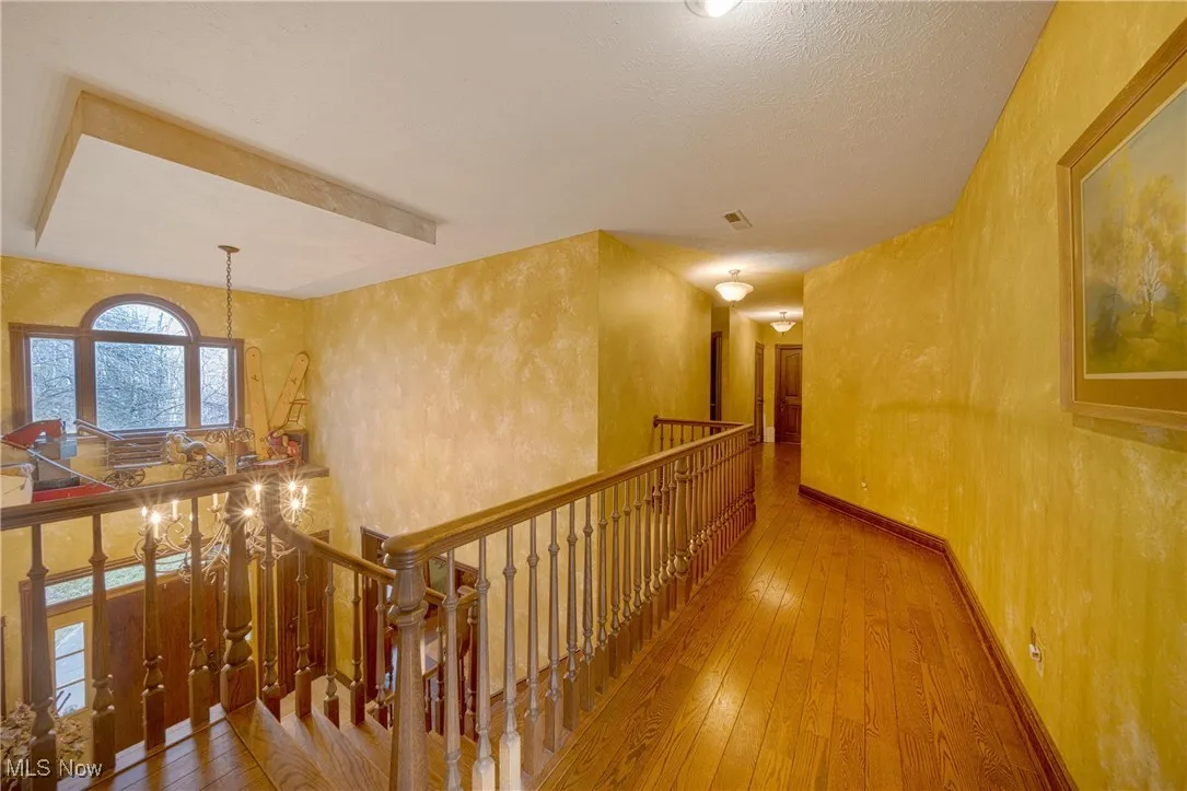 Corridor with light hardwood / wood-style floors and a textured ceiling