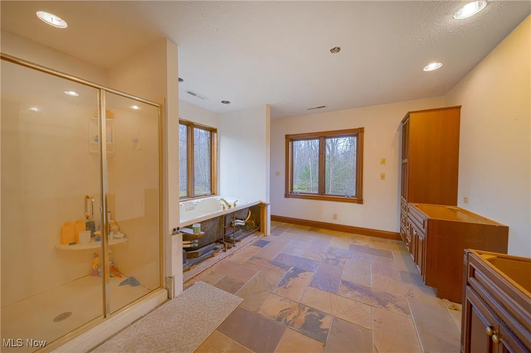 Bathroom featuring vanity, tile floors, and separate shower and tub