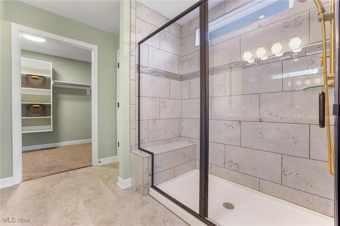 Bathroom featuring walk in shower and tile floors