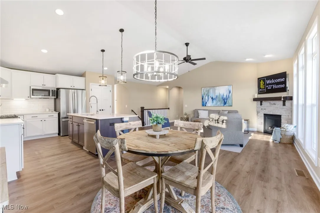 Dining space with lofted ceiling, sink, ceiling fan, and light hardwood flooring