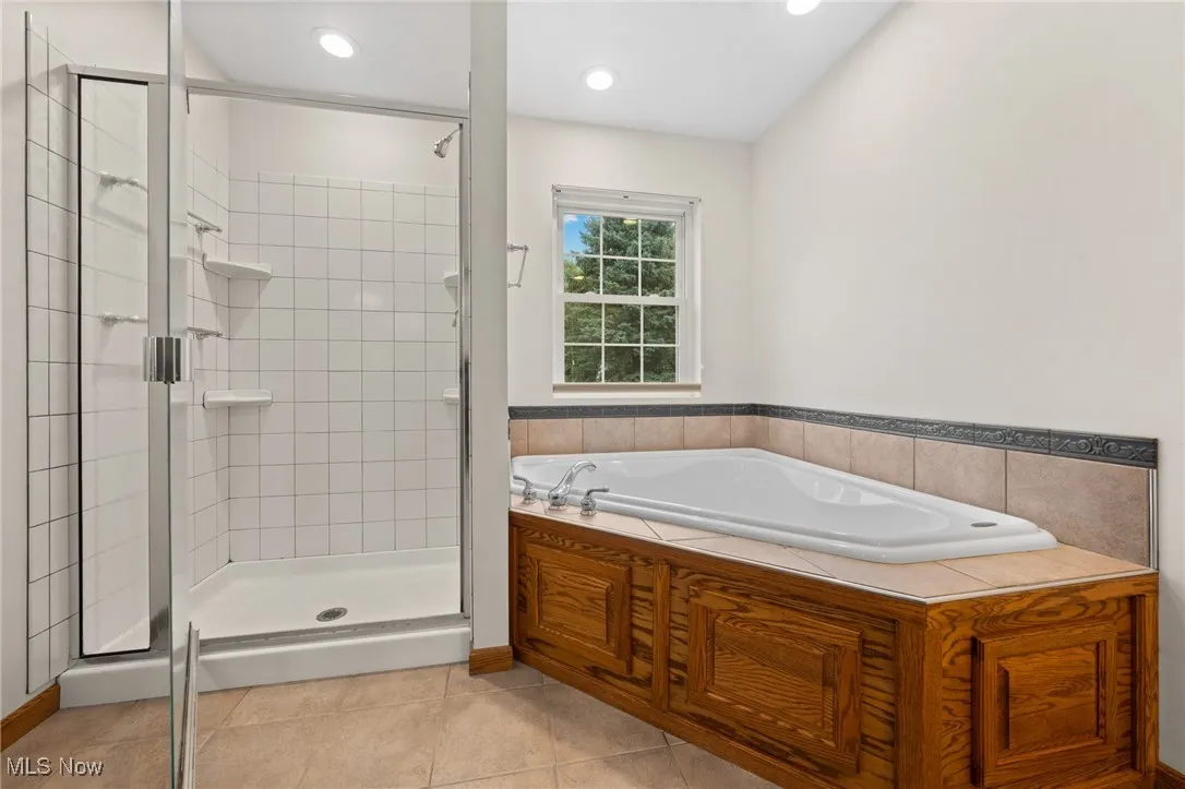 Bathroom featuring tile patterned flooring and separate shower and tub
