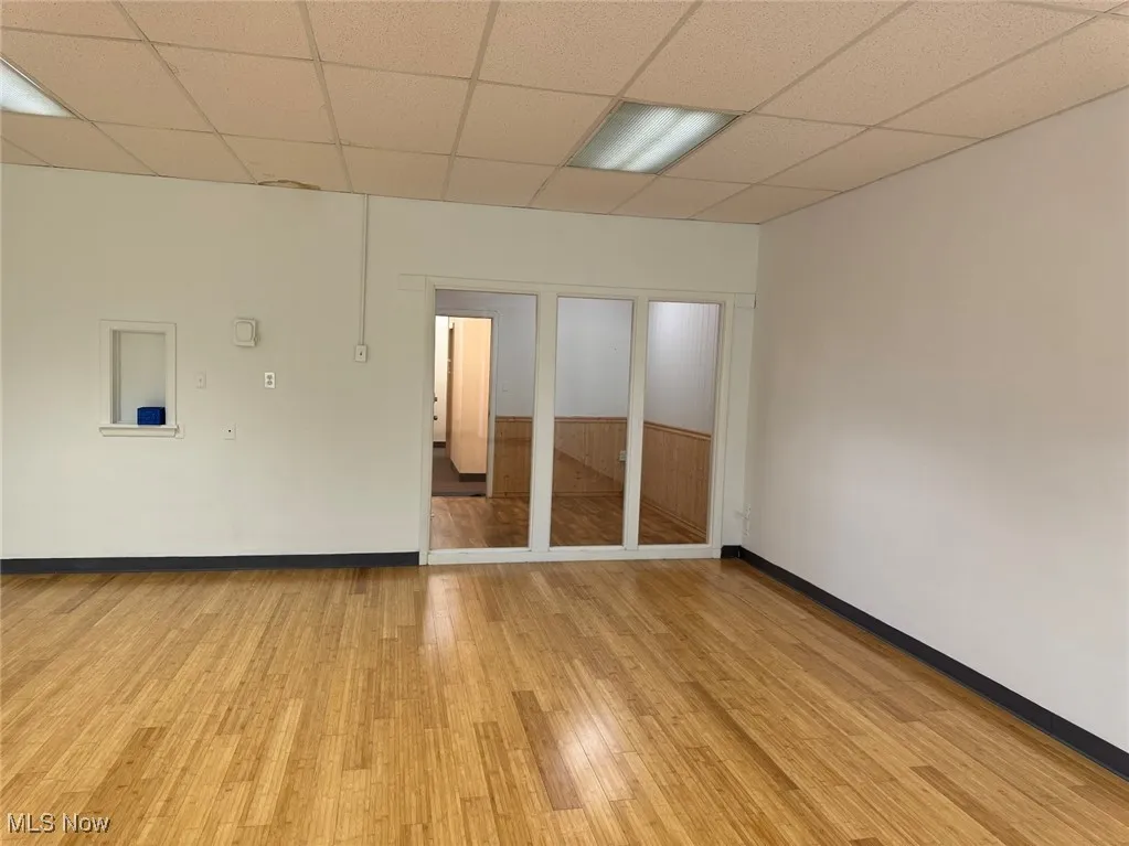 Unfurnished room featuring a paneled ceiling and light hardwood / wood-style floors