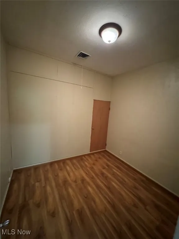 Unfurnished room featuring dark hardwood / wood-style flooring