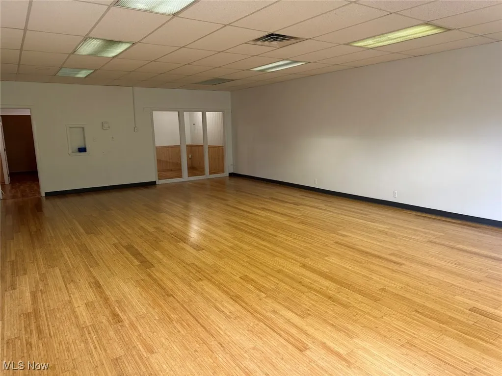 Spare room with a paneled ceiling and light hardwood / wood-style flooring