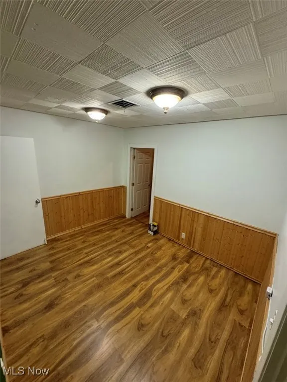 Unfurnished room featuring wood walls and hardwood / wood-style flooring