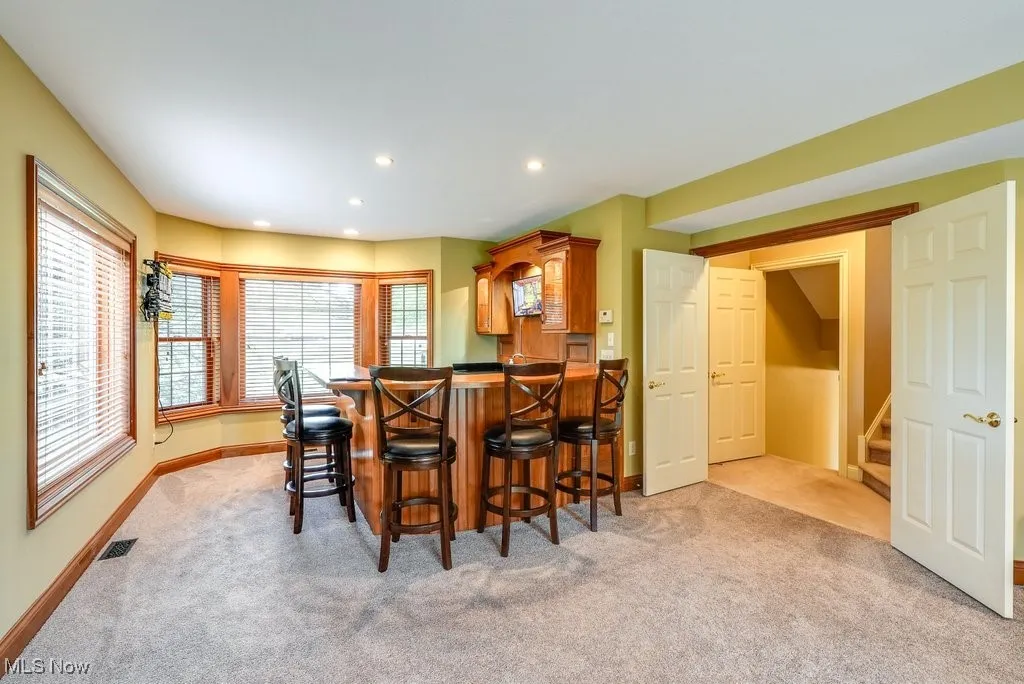 Dining area featuring bar and light colored carpet