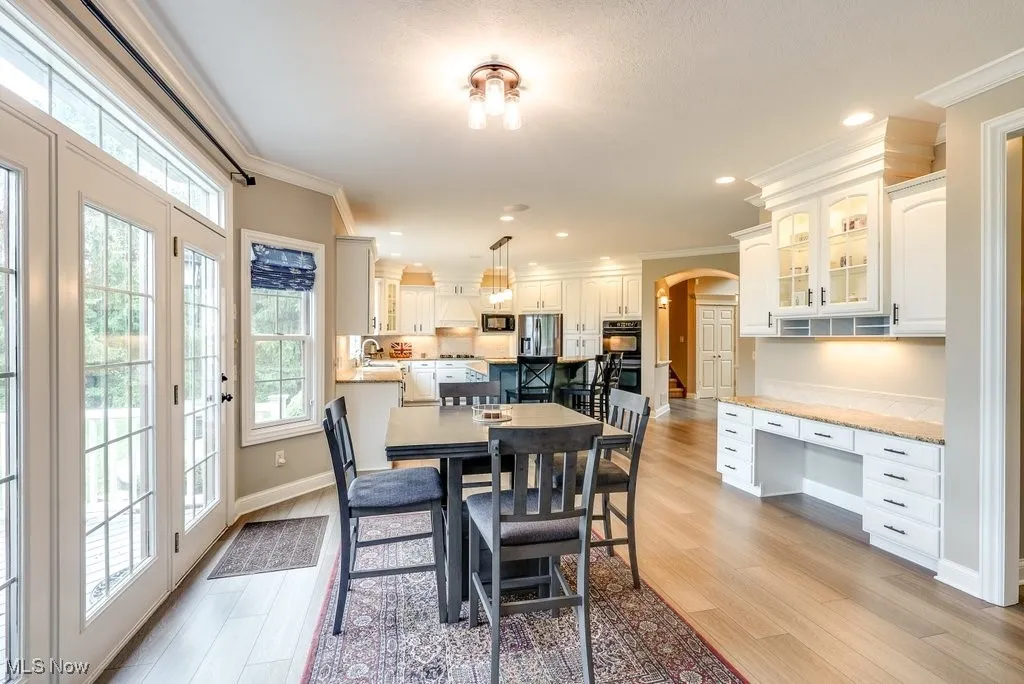 Dining space with light hardwood / wood-style flooring, built in desk, sink, and crown molding