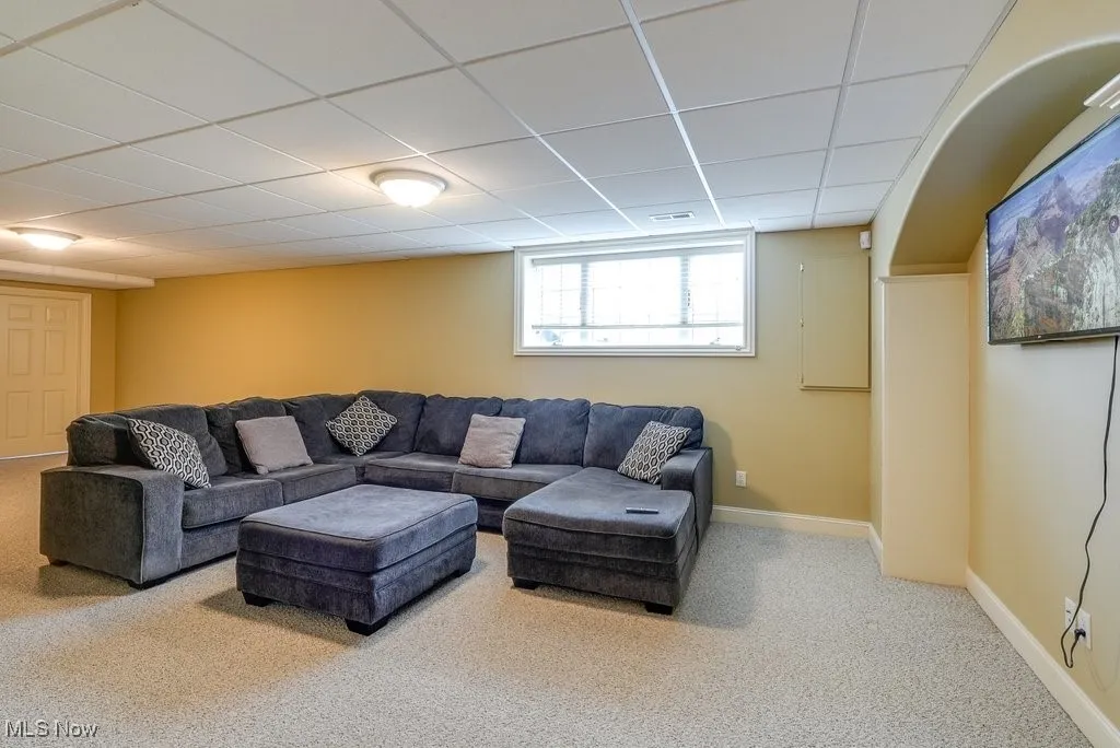 Living room with a paneled ceiling and carpet flooring