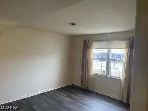 Unfurnished room featuring dark hardwood / wood-style flooring