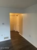 Unfurnished room with dark hardwood / wood-style flooring