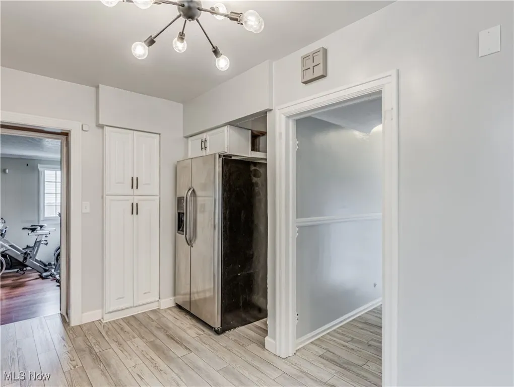 Kitchen featuring stainless steel refrigerator with ice dispenser, an inviting chandelier