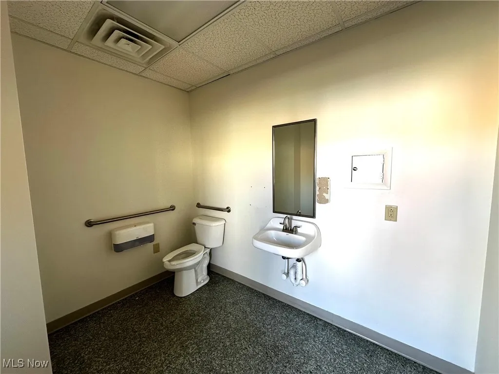 Bathroom with sink, a paneled ceiling, and toilet