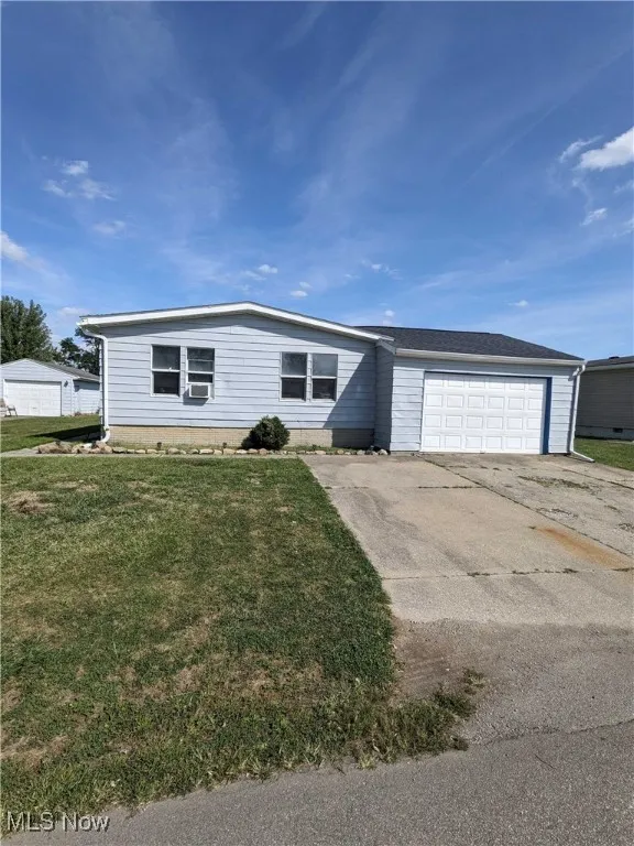 View of front of house featuring a garage and a front lawn