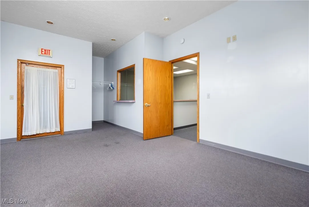 Empty room featuring a textured ceiling and carpet floors