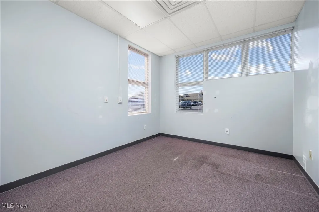 Carpeted spare room with a paneled ceiling