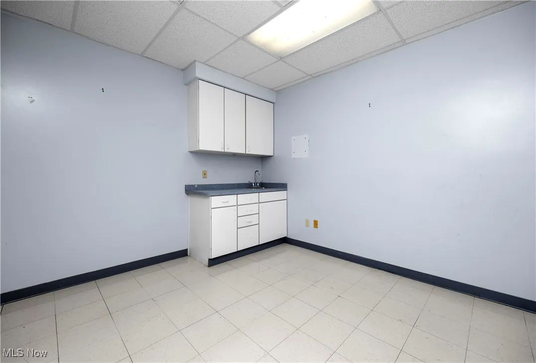 Kitchen featuring white cabinets, sink, and a drop ceiling