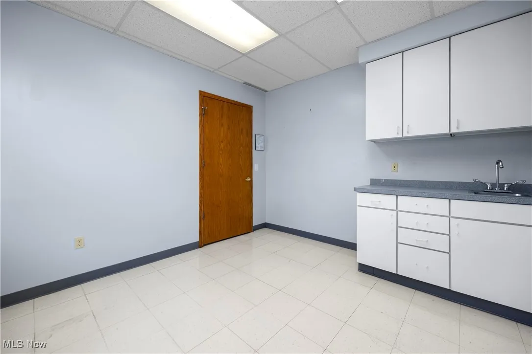 Kitchen featuring white cabinets, sink, and a drop ceiling