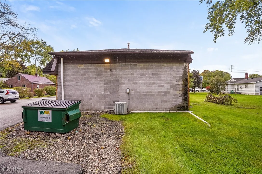 View of property exterior with central air condition unit and a lawn