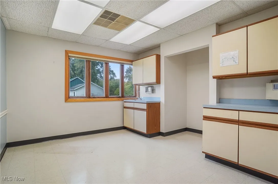 Kitchen featuring white cabinetry and a drop ceiling
