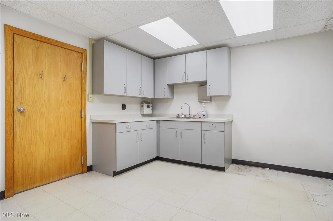 Kitchen with sink, gray cabinetry, and a paneled ceiling