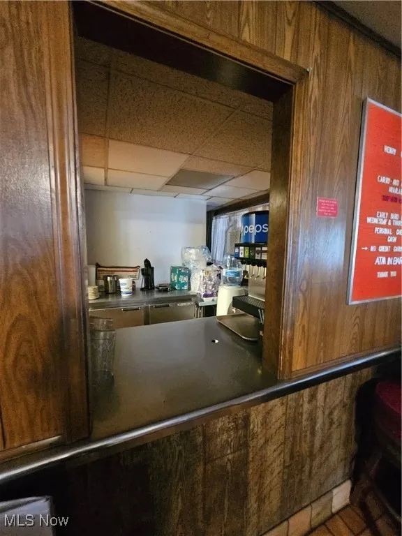 Kitchen with a drop ceiling and wooden walls