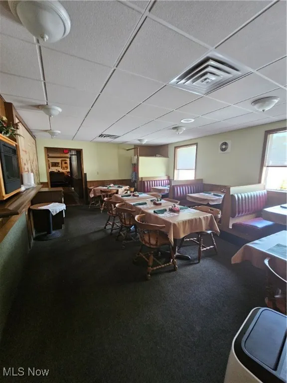 Carpeted dining room with a paneled ceiling