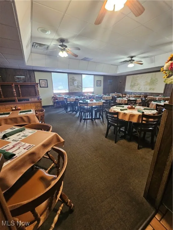 Dining room featuring wood walls and carpet floors